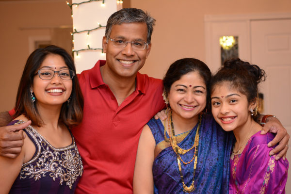 Karlekar (left) poses with her parents and little sister.