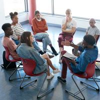 researchers and community members sitting in a circle and conversing