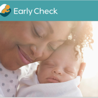 woman holding infant and smiling